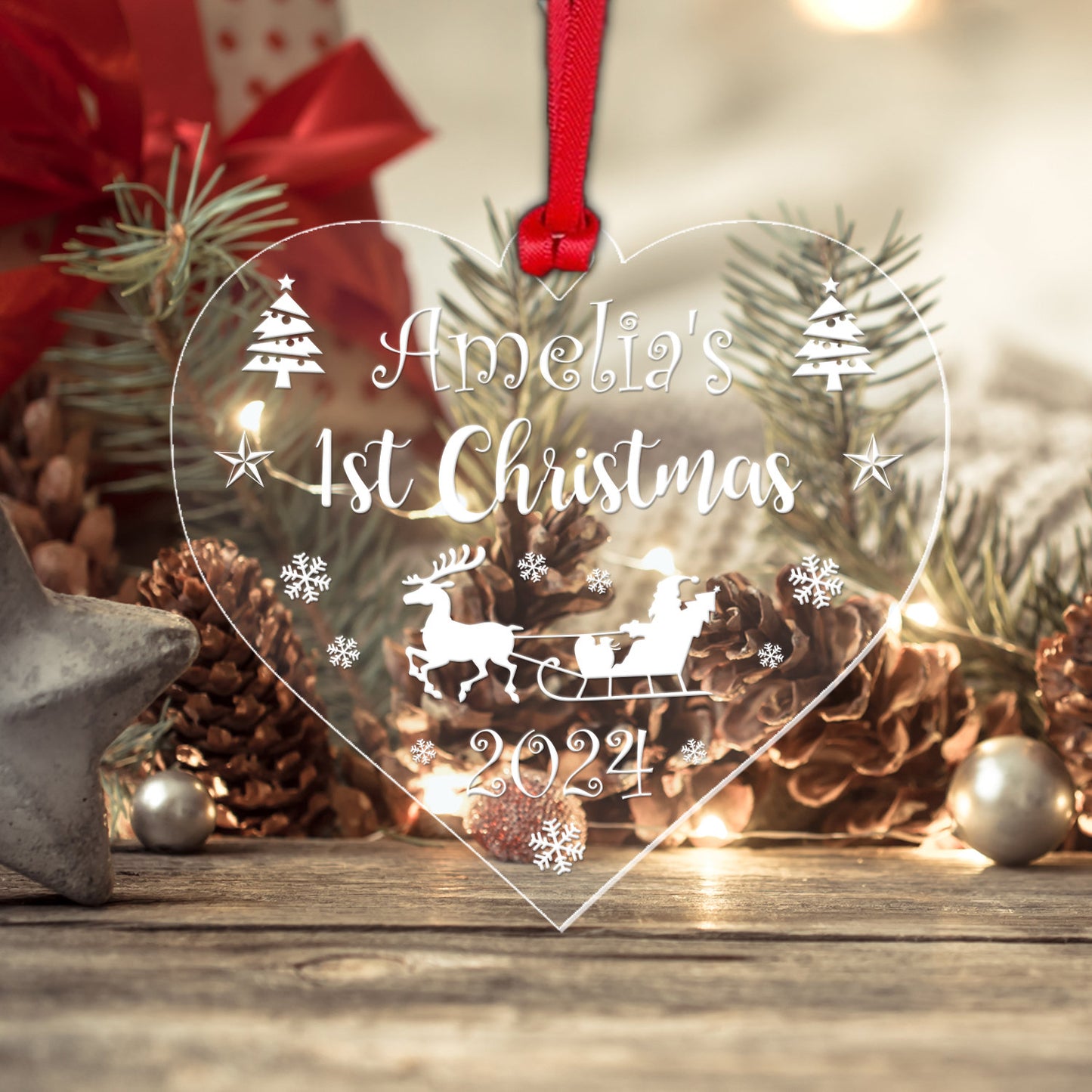 a glass heart shaped ornament with a santa sleigh
